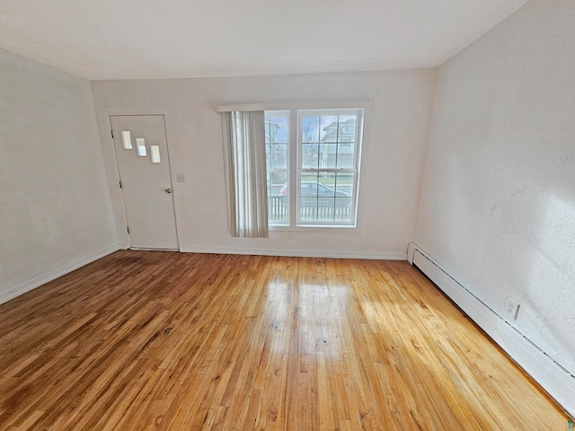 interior space featuring wood-type flooring and a baseboard heating unit