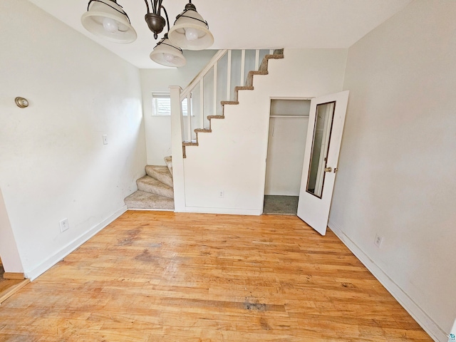 stairs with a chandelier and hardwood / wood-style floors