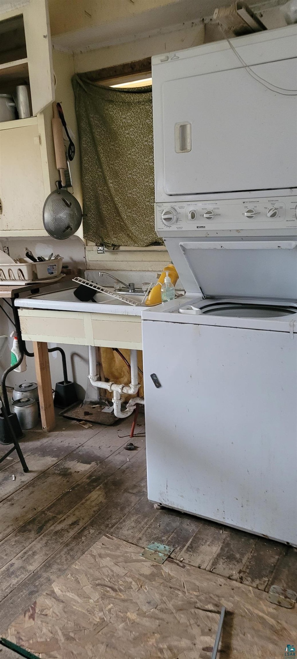 laundry area with hardwood / wood-style floors and stacked washer / drying machine