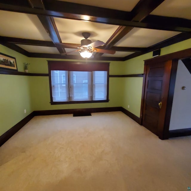 carpeted empty room featuring beam ceiling, ceiling fan, and coffered ceiling