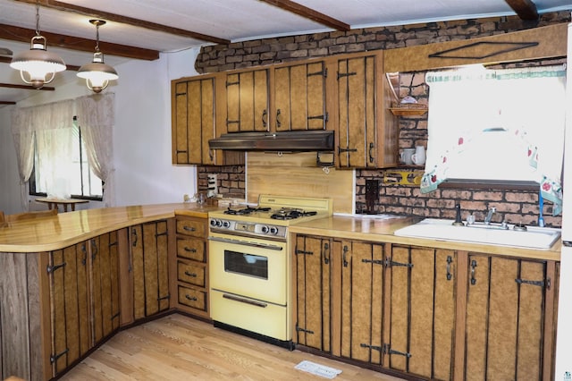 kitchen with light wood-type flooring, white range oven, sink, beam ceiling, and decorative light fixtures