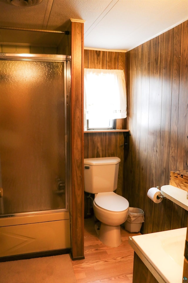 full bathroom featuring vanity, toilet, wood-type flooring, and wooden walls