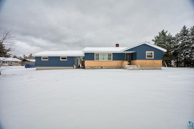 view of snow covered back of property