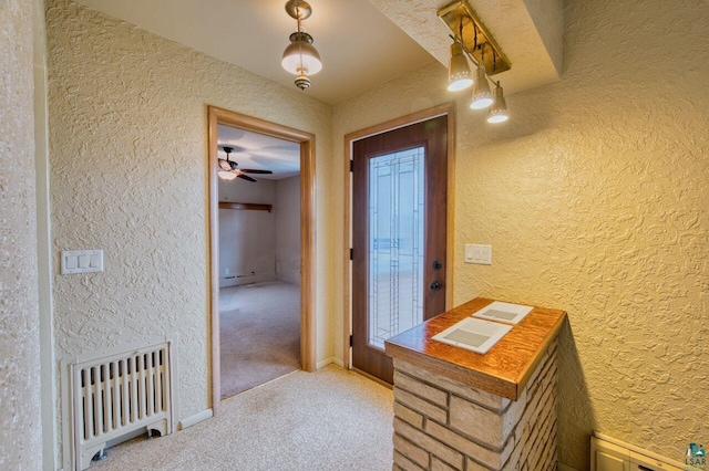 hallway featuring light carpet and radiator heating unit