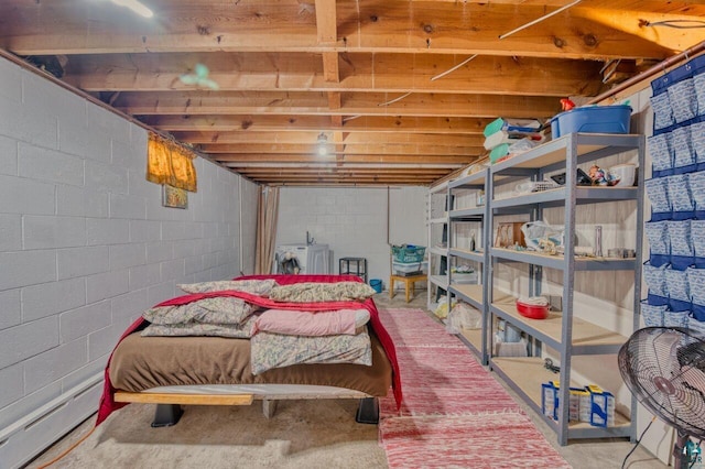 bedroom featuring concrete flooring, washer / clothes dryer, and baseboard heating