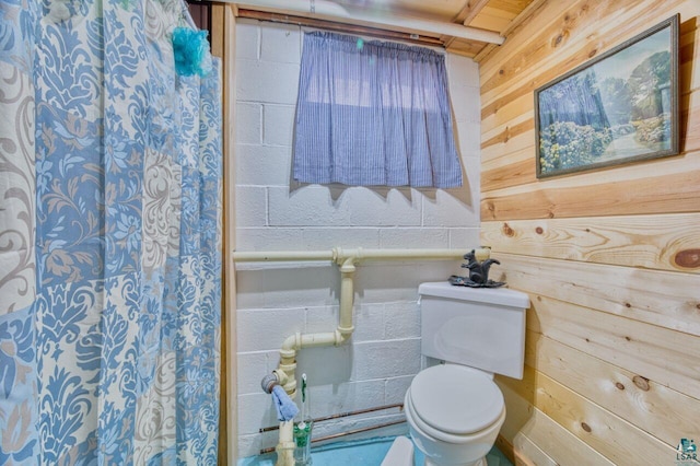 bathroom with wood walls and toilet