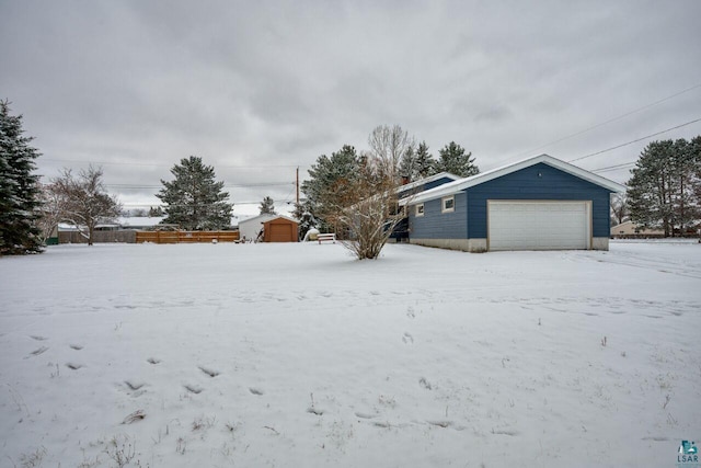 yard covered in snow featuring a storage shed