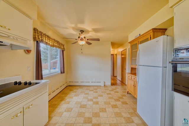 kitchen featuring cooktop, white fridge, oven, and a baseboard radiator