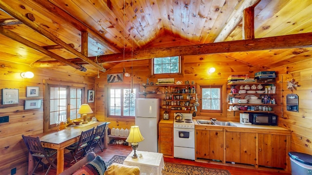 kitchen featuring wood walls, hardwood / wood-style floors, lofted ceiling with beams, and white appliances