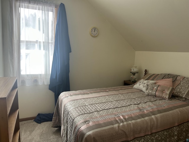 carpeted bedroom with lofted ceiling