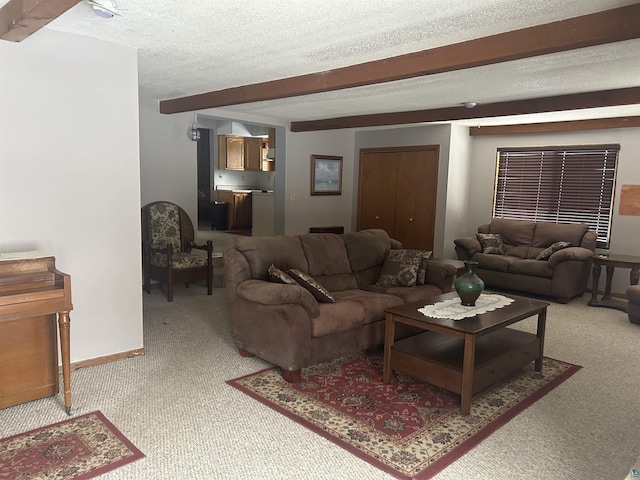 living room featuring carpet flooring, beam ceiling, and a textured ceiling