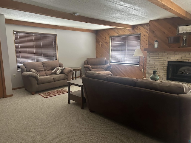 living room featuring carpet flooring, beamed ceiling, wood walls, a textured ceiling, and a fireplace