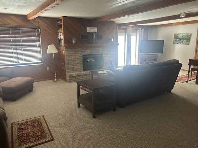 carpeted living room with beam ceiling, wood walls, and a textured ceiling