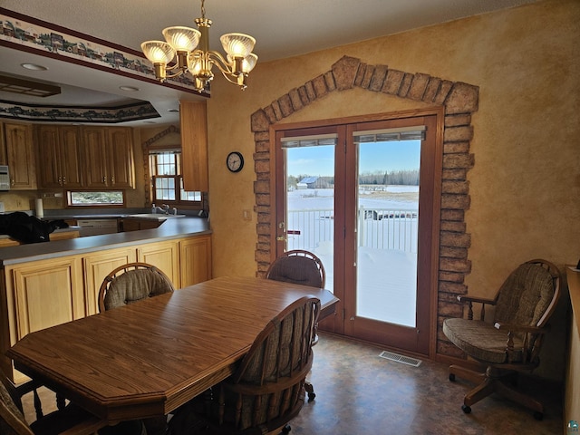 dining room with sink and a chandelier