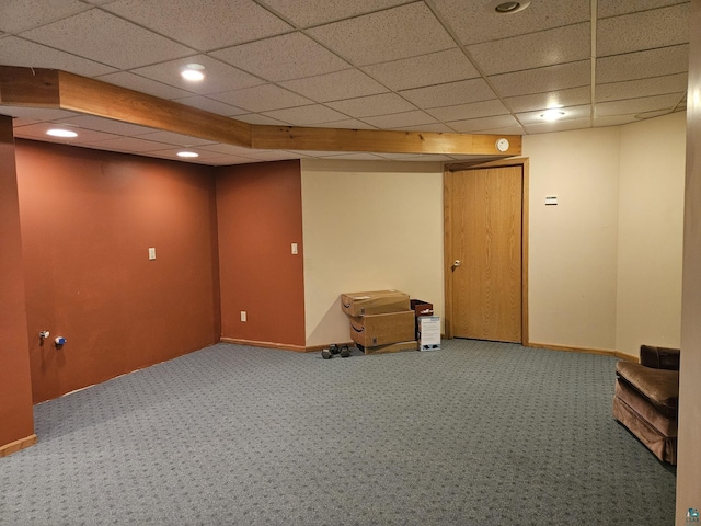 basement featuring a paneled ceiling and carpet floors