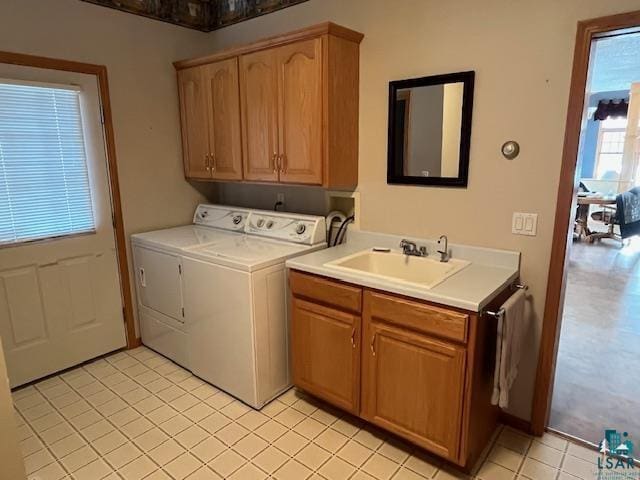 clothes washing area featuring washer and clothes dryer, cabinets, light tile patterned floors, and sink