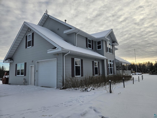 view of snow covered exterior with a garage