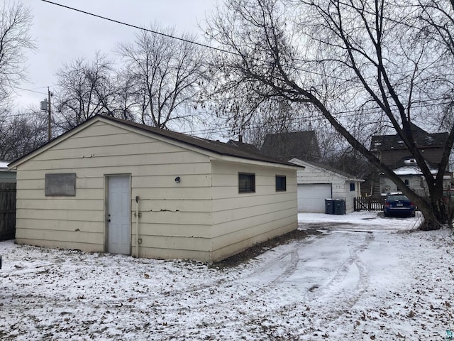 snow covered structure featuring a garage