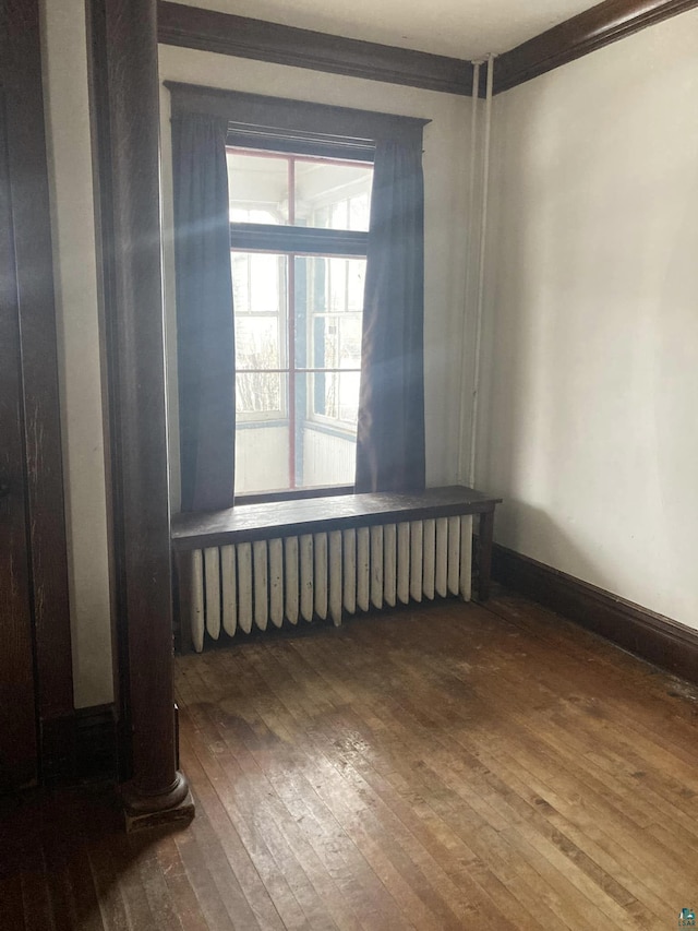 unfurnished room featuring hardwood / wood-style flooring and ornamental molding