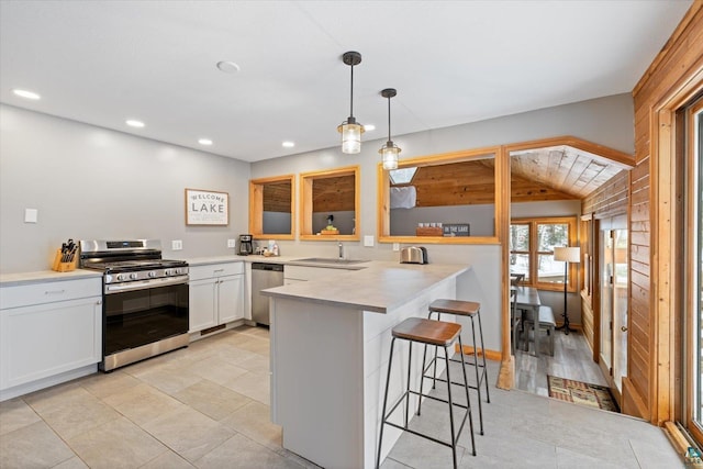 kitchen with hanging light fixtures, stainless steel appliances, lofted ceiling, a breakfast bar, and white cabinets