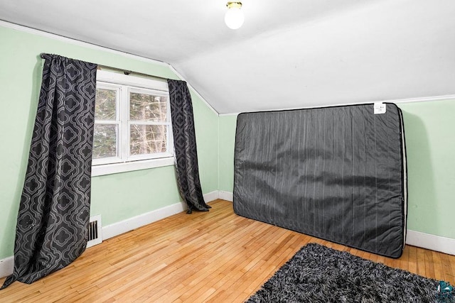 bedroom featuring hardwood / wood-style flooring and vaulted ceiling