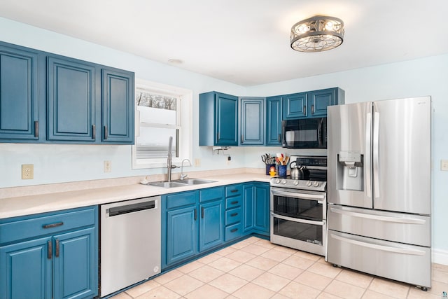 kitchen with light tile patterned flooring, blue cabinets, sink, and appliances with stainless steel finishes