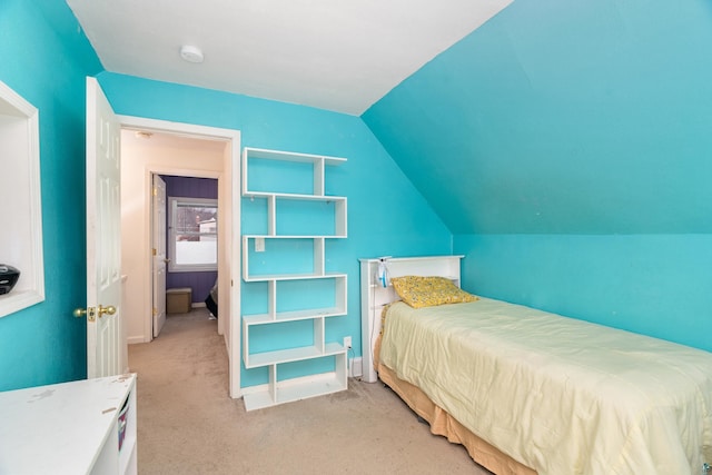 bedroom featuring light colored carpet and vaulted ceiling