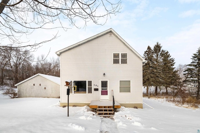 view of snow covered back of property