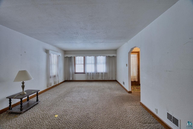 carpeted empty room with a textured ceiling