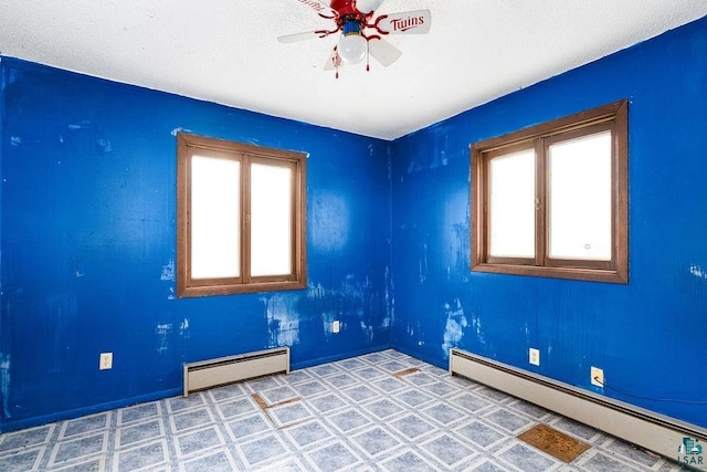 spare room featuring ceiling fan and a baseboard heating unit