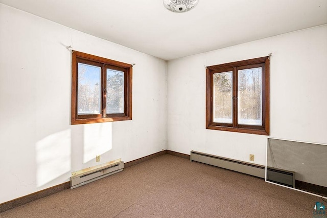 empty room with plenty of natural light, carpet, and a baseboard heating unit