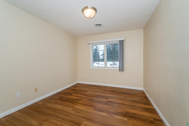 unfurnished room with dark wood-type flooring