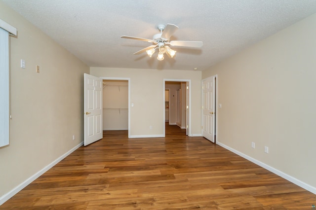 unfurnished bedroom featuring ceiling fan, a textured ceiling, and hardwood / wood-style flooring