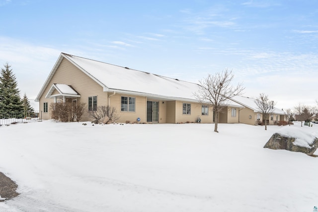 view of snow covered back of property