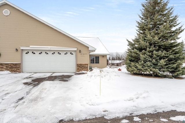 view of snow covered exterior with a garage