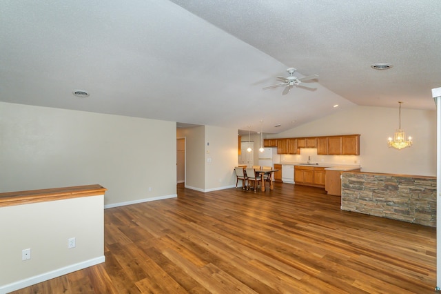 unfurnished living room with ceiling fan with notable chandelier, dark hardwood / wood-style floors, lofted ceiling, and sink