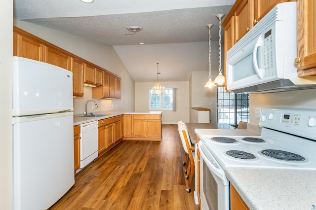 kitchen with white appliances, vaulted ceiling, pendant lighting, wood-type flooring, and a chandelier