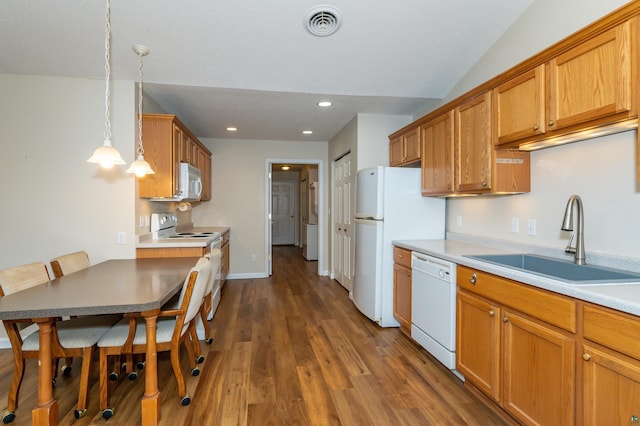 kitchen with dark hardwood / wood-style flooring, white appliances, vaulted ceiling, sink, and hanging light fixtures