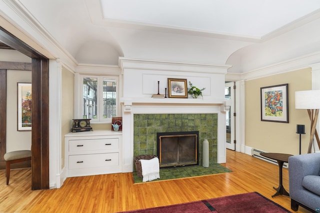 living room with a tiled fireplace and light hardwood / wood-style floors