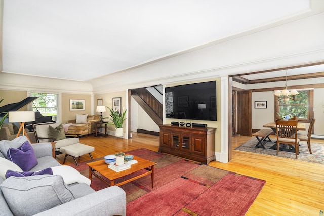 living room with a chandelier, hardwood / wood-style flooring, and ornamental molding