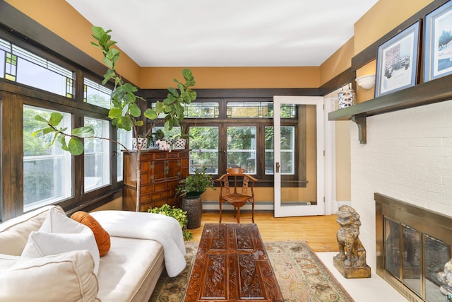 sunroom / solarium with a baseboard heating unit and a brick fireplace