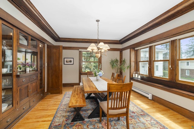 dining room with a chandelier, a baseboard radiator, light hardwood / wood-style flooring, and a wealth of natural light