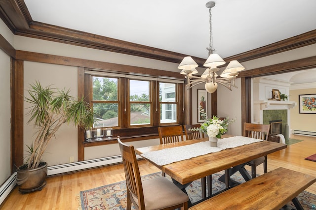 dining room with crown molding, light hardwood / wood-style floors, a baseboard radiator, and a notable chandelier