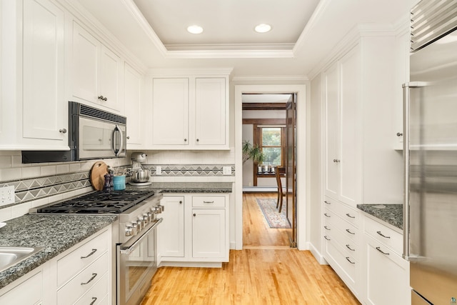 kitchen featuring backsplash, white cabinets, light wood-type flooring, and high end appliances