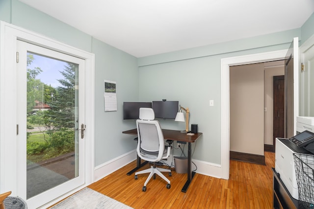 home office with light hardwood / wood-style flooring