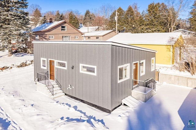 view of snow covered rear of property