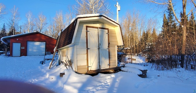 snow covered structure with a garage