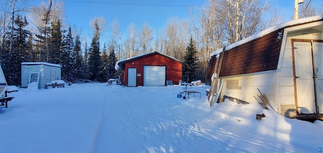 yard covered in snow with a shed and a garage