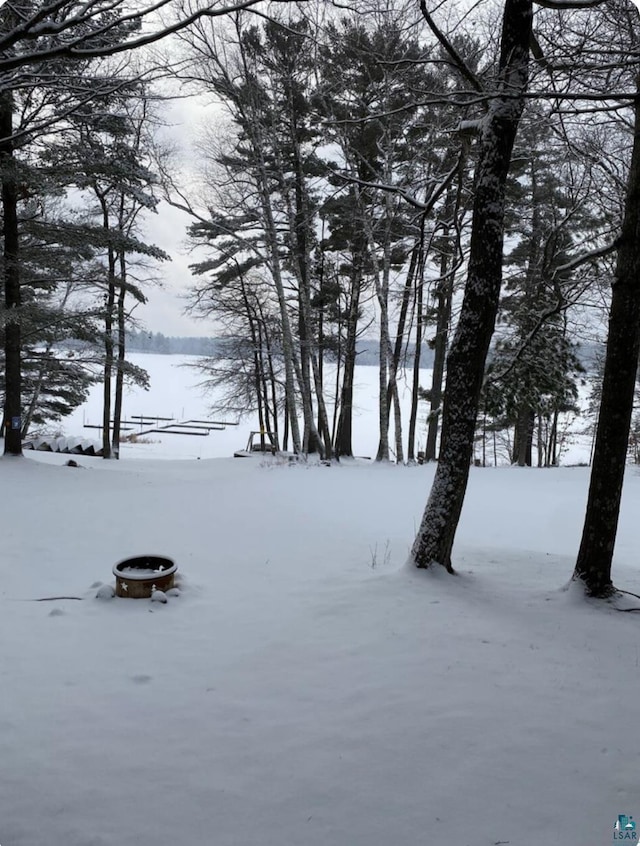 snowy yard with an outdoor fire pit