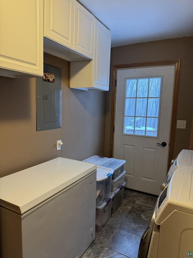 laundry area with cabinets, electric panel, and washer and clothes dryer